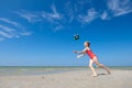 Cute teen girl playing and having fun with ball on beach at sunny summer day Royalty Free Stock Photo