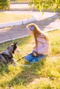 Cute teen girl with red long hair walks with her husky breed dog in the autumn park. Children and dogs.