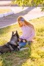 Cute teen girl with red long hair walks with her husky breed dog in the autumn park. Children and dogs.