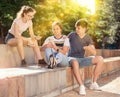 Teen girl with smartphone ignoring friends outdoor Royalty Free Stock Photo