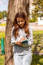 Cute teen girl writes with a pen in a notebook near in a park. Selective focus Royalty Free Stock Photo