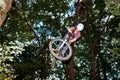 Cute teen jumping with his bike over a natural ramp in the fores Royalty Free Stock Photo