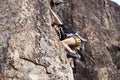 Cute teen kid climbing on rock with insurance, lifestyle sport people concept Royalty Free Stock Photo