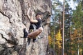 Cute teen kid climbing on rock with insurance, lifestyle sport people concept Royalty Free Stock Photo