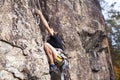 Cute teen kid climbing on rock with insurance, lifestyle sport people concept Royalty Free Stock Photo