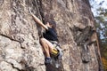 Cute teen kid climbing on rock with insurance, lifestyle sport people concept Royalty Free Stock Photo