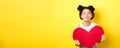 Cute teenage asian girl dreaming of true love, close eyes and showing big red heart cutout, waiting for soulmate on Royalty Free Stock Photo