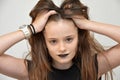 Teenage girl with black lips tousles her hair