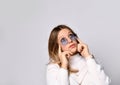 Teenage girl in sunglasses, watch, bracelet and sweater. She is looking up, touching her face, posing isolated on white. Close up Royalty Free Stock Photo