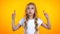 Cute teenage girl crossing fingers and looking up, superstitious belief in luck Royalty Free Stock Photo