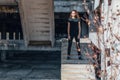 Cute teenage girl with curly hair standing on the stairs. Abandoned building, unfinished construction