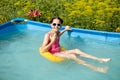 Cute teenage girl drinking a drink relaxing in the pool at the hotel Royalty Free Stock Photo