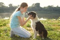 teenage girl embrace australian shepherd puppy dog in summer. in forest Royalty Free Stock Photo