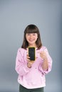 Cute teenage girl with freckles pointing at new smartphone