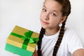 cute teenage girl is holding a gift in a beautiful box and looking at camera. Happy birthday, Merry Christmas. Royalty Free Stock Photo