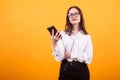 Cute teenage girl holding a mobile phone and listening music from it Royalty Free Stock Photo