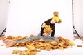 Teen girl sitting on dried leaves in photo atelier