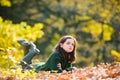 Cute teenage girl lying on autumn maple leaves at fall outdoors. Beautiful fall time in nature. Royalty Free Stock Photo