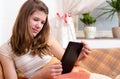 Cute teenage girl reading novels on ebook reader