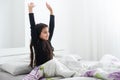 Cute teenage girl stretching on the bed in her room having fun. Royalty Free Stock Photo