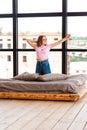 Cute teenage girl stretching on the bed in her room Royalty Free Stock Photo