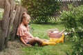 Cute teenage girl works in the garden, watering flowers and flower beds. Family fun in the summer Royalty Free Stock Photo