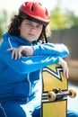 Cute teenage skateboarder posing for the camera outside