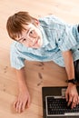 Cute teenaged boy using computer on floor