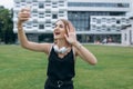 Cheerful young girl teenager taking selfie with headphones. Cute beautiful girl taking a selfie with her smart phone Royalty Free Stock Photo