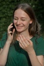 Cute teenager girl talking and smiling on mobile phone outdoors. Communication and education Royalty Free Stock Photo