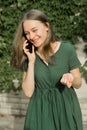 Cute teenager girl talking and smiling on mobile phone outdoors. Communication and education Royalty Free Stock Photo