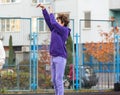 Cute teenager in violet hoodie playing basketball. Young boy with ball learning dribble and shooting on the city court. Hobby Royalty Free Stock Photo