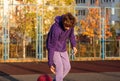 Cute teenager in violet hoodie playing basketball. Young boy with ball learning dribble and shooting on the city court. Hobby Royalty Free Stock Photo