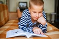Cute ten year old boy doing homework at home on couch lying on his back Royalty Free Stock Photo