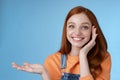 Cute tender chatismatic glad smiling redhead girl presenting awesome product show object palm hold hand raised blank