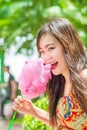 Cute Thai girl is eating pink candyfloss with joy Royalty Free Stock Photo