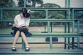 Cute Thai schoolgirl is sitting and reading on a stand in vintage color