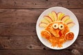 Cute Thanksgiving turkey pancakes on a white plate, top view against a rustic wood background