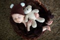 Cute three months old baby with bear hat in a basket, sleeping Royalty Free Stock Photo