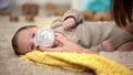 Cute tiny child drinking milk formula from bottle, vitamin complex for babies