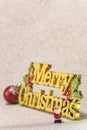 Cute tiny figurine of Santa Claus on a glitter silver snow background with the golden words Merry Christmas and a Christmas Tree Royalty Free Stock Photo