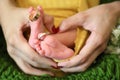 Cute tiny Saudi newborn baby girl feet closeup rings in thumbs female holding hands Royalty Free Stock Photo