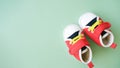 Cute tiny sneakers on green background. Footwear for infant baby. Copy space. Babyhood concept