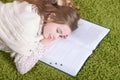 Portrait of cute tired schoolgirl sleeping after studying at home