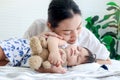 Cute toddle baby girl infant sleeping during hug teddy bear toy on bed, young beautiful mother gentle touch sleepy daughter kid, Royalty Free Stock Photo