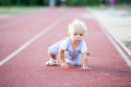 Cute toddler baby boy on a running path on a stadium Royalty Free Stock Photo