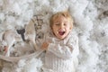 Cute toddler blond boy, playing with white wooden horse in the snow Royalty Free Stock Photo