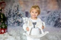 Cute toddler blond boy, playing with white wooden horse in the snow Royalty Free Stock Photo