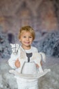 Cute toddler blond boy, playing with white wooden horse in the snow Royalty Free Stock Photo