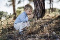 Cute toddler blowing dandelion in the forest